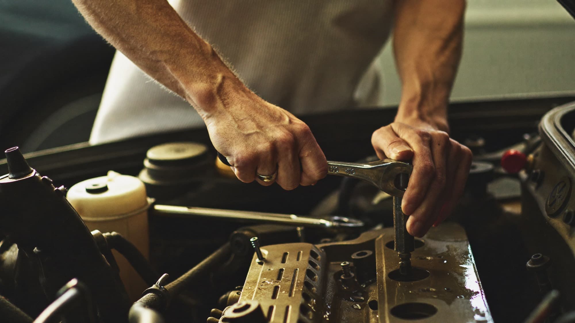 A mechanic working on a car engine at Accurate Auto Center