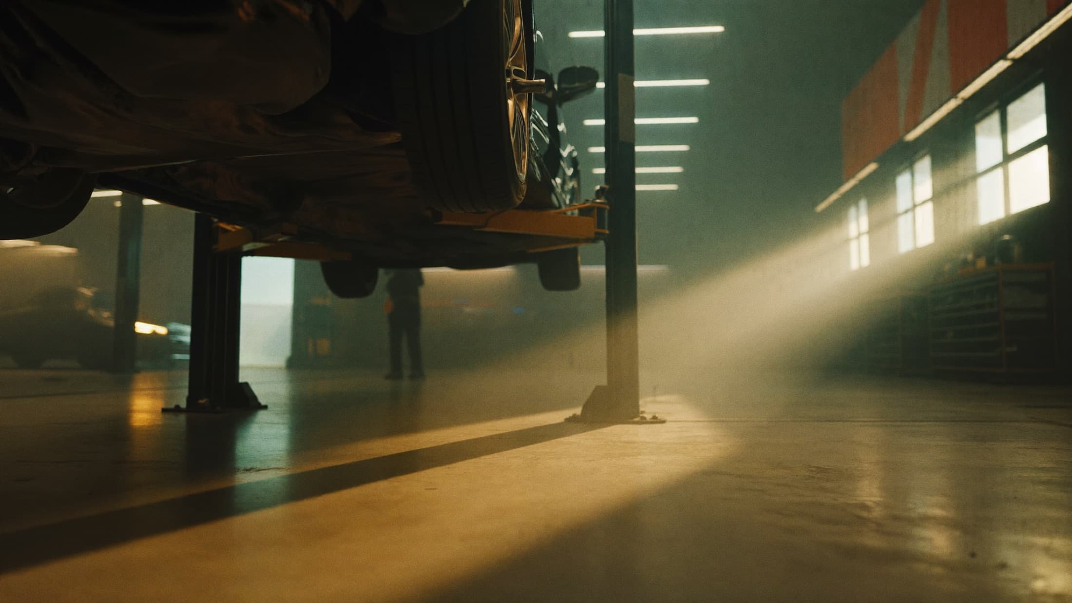 A car raised on a lift inside the Accurate Auto Center service bay, lit by afternoon sun